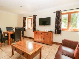 A living room with a dining area and television at The Annexe in Litcham