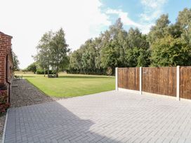 An outdoor space with a paved area and trees at The Annexe in Litcham