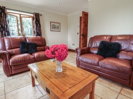 A living room with sofas and a table with flowers at The Annexe in Litcham