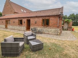 An outdoor area with a brick building and seating at The Annexe in Litcham
