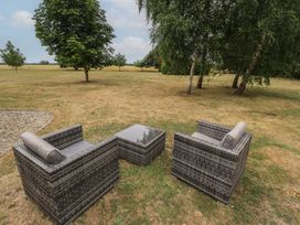 A seating area with rattan chairs and a table at The Annexe in Litcham