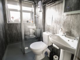 A bathroom with a toilet sink shower and a window at Chy Bean in Abergele