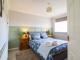 A bedroom with a bed and bedside table at Chy Bean in Abergele