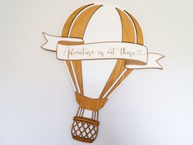 A decorative hot air balloon wall art with a banner saying Adventure is out there at Chy Bean in Abergele