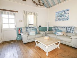 A living room with sofa and coffee table at Dovecote in Gorran Haven