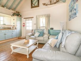 A living room with a sofa and coffee table at Dovecote in Gorran Haven