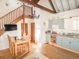 A kitchen with a table and chairs at Dovecote in Gorran Haven