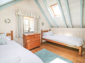 A bedroom with two beds and a chest of drawers at Dovecote in Gorran Haven