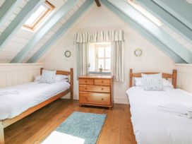 A bedroom with two beds and a dresser at Dovecote in Gorran Haven