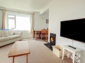 A living room with a sofa and dining area at Treverrion in Gorran Haven