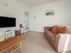 A living room with a sofa and television at Treverrion in Gorran Haven