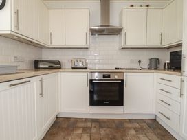 A kitchen with cabinets countertop and appliances at Treverrion in Gorran Haven