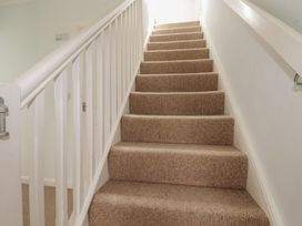 A staircase with carpet and a handrail at Treverrion in Gorran Haven