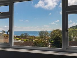 A view from a window showing the sea and houses at Treverrion, Gorran Haven