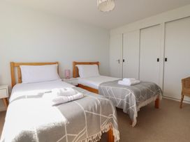 A bedroom with two beds and a nightstand at Treverrion in Gorran Haven