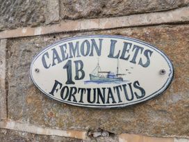 A sign stating CAEMON LETS 1B FORTUNATUS on a stone wall in Whitby