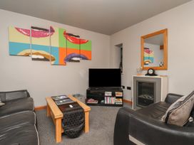 A living room with a couch, coffee table, and television at Fortunatus in Whitby