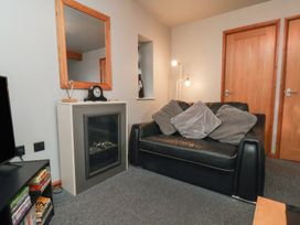 A living room with a sofa and a mirror at Fortunatus in Whitby