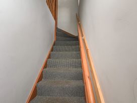 A staircase with carpet and wooden handrail at Fortunatus in Whitby