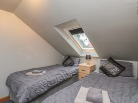 A bedroom with two beds and a bedside table at Fortunatus in Whitby