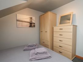 A bedroom with a bed, towels, wardrobe, and a chest of drawers at Fortunatus in Whitby