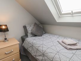A bedroom with a single bed and bedside lamp at Fortunatus in Whitby