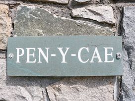 A stone plaque with the text PEN-Y-CAE mounted on a stone wall at Pen Y Cae in Llansannan