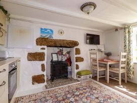 A kitchen with a table and chairs at Longview Cottage in Penwithick neat St Austell
