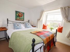 A bedroom with a bed and lamp at Longview Cottage in Penwithick neat St Austell