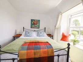 A bedroom with a bed and nightstands at Longview Cottage Penwithick near St Austell