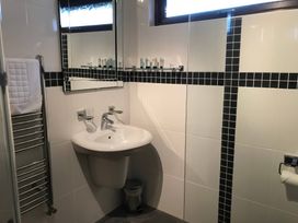 A bathroom with a sink, mirror, and towel radiator at Snowdrop in Saltburn-by-the-Sea