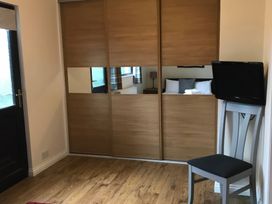 A bedroom with a mirror wardrobe and television at Snowdrop in Saltburn-by-the-Sea