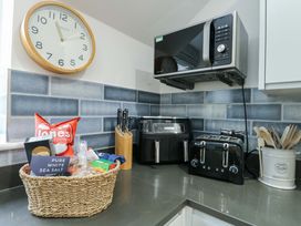 A kitchen with appliances and utensils at Maelog, 14 Tides Reach Rhosneigr