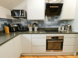 A kitchen with appliances and cabinets at Maelog, 14 Tides Reach Rhosneigr