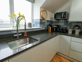 A kitchen with a sink and appliances at Maelog, 14 Tides Reach Rhosneigr