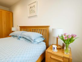 A bedroom with a bed and lamp at Maelog, 14 Tides Reach in Rhosneigr