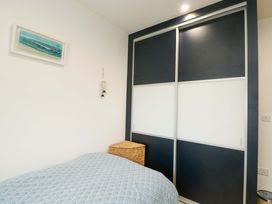 A bedroom with a bed and wardrobe at Maelog, 14 Tides Reach, Rhosneigr
