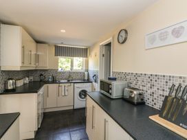 A kitchen with cabinets countertop microwave toaster knives and washing machine at Badger View in Culverstone Green near Chatham
