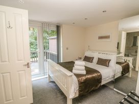 A bedroom with a double bed with towels stacked on it and sliding glass doors leading to an outdoor area at Badger View in Culverstone Green near Chatham