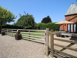 An outdoor area with a table and chairs under an umbrella at The Wainhouse in Bockleton near Tenbury Wells