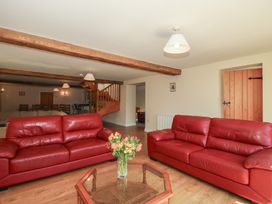 A living room with red sofas and a coffee table at The Wainhouse in Bockleton near Tenbury Wells