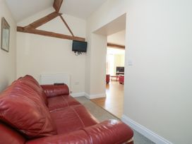 A living room with a red sofa and a television at The Wainhouse in Bockleton near Tenbury Wells