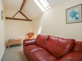 A snug with a red sofa and a wicker chair at The Wainhouse in Bockleton near Tenbury Wells