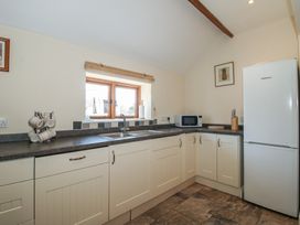 A kitchen with sink and refrigerator at The Wainhouse in Bockleton near Tenbury Wells