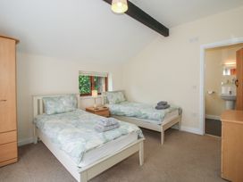A bedroom with two single beds and a wardrobe at The Wainhouse in Bockleton near Tenbury Wells