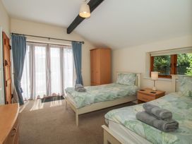 A bedroom with two beds and a wardrobe at The Wainhouse in Bockleton near Tenbury Wells
