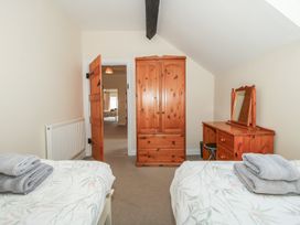 A bedroom with two beds and a wardrobe at The Wainhouse in Bockleton near Tenbury Wells