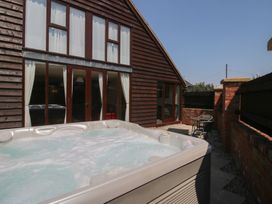 An outdoor area with a hot tub and chairs at The Wainhouse in Bockleton near Tenbury Wells