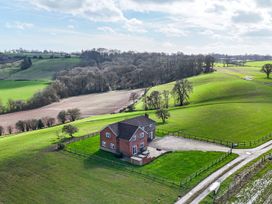 A house surrounded by fields and trees at Wood Cottage in Tenbury Wells