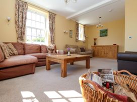 A living room with sofas a wooden coffee table a sideboard and a basket with newspapers at Foremans House in Bridlington